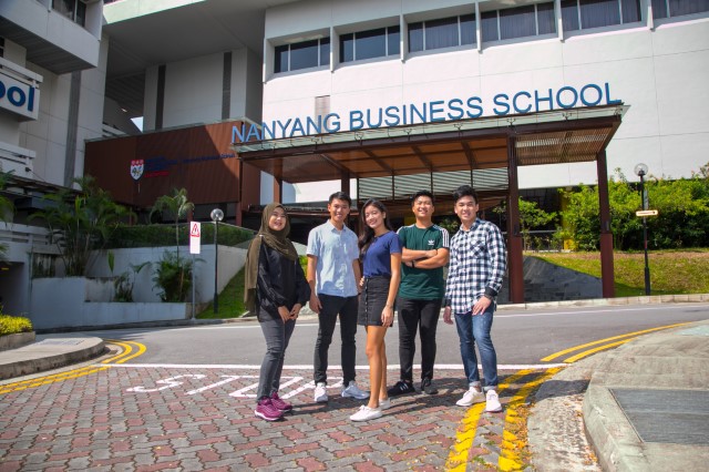 Group of undergraduates standing in front of a Nanyang Business School building