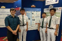 Winning team of students with their mentor in front of their project