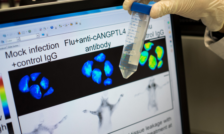 A test tube in front of a research document