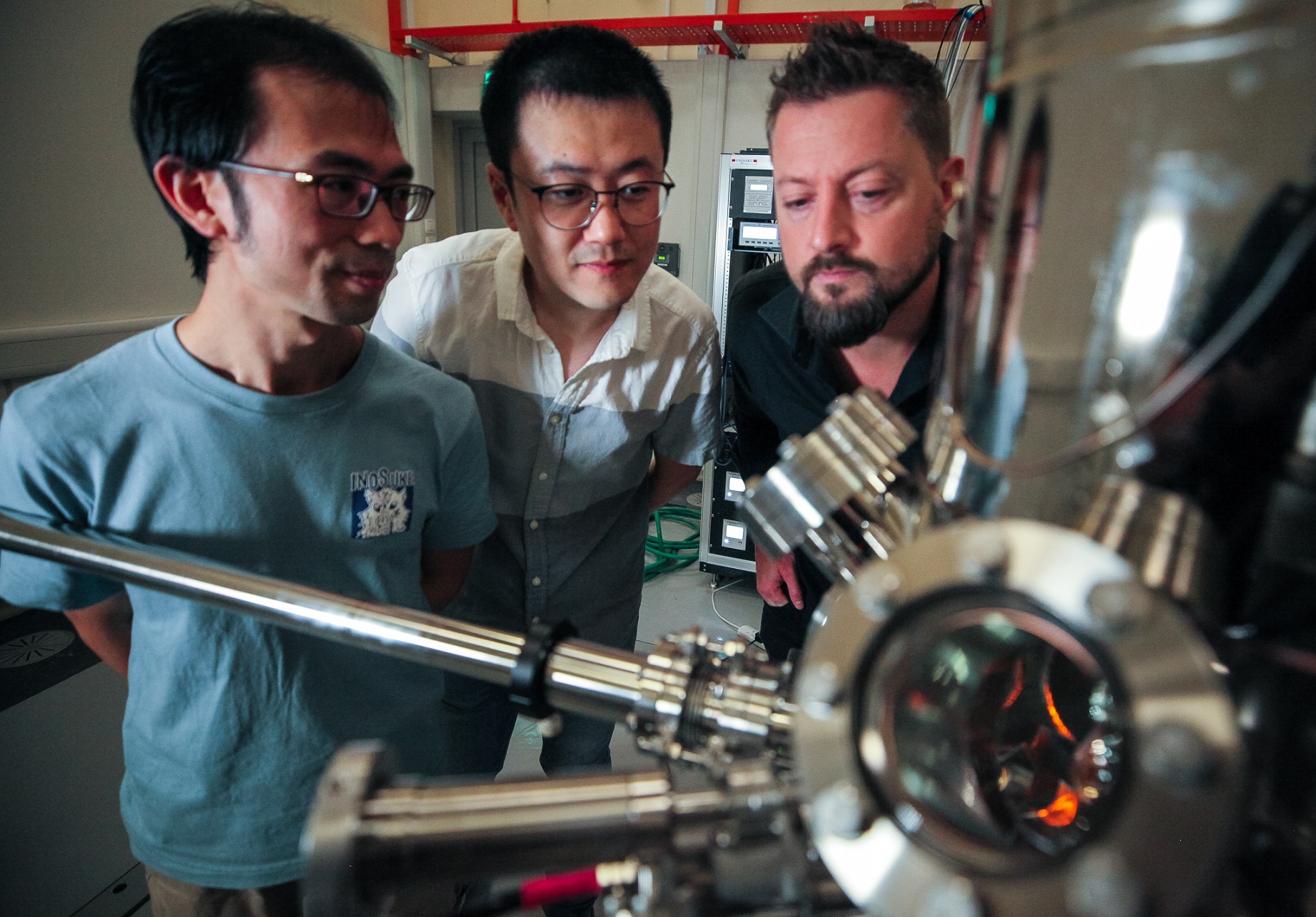 Dr Que Yande, a senior research fellow from NTU Singapore’s SPMS; PhD student Jia Junxiang, the first author of the study; and Asst Prof Bent Weber from the school who led the research, with a scanning tunnelling microscope.