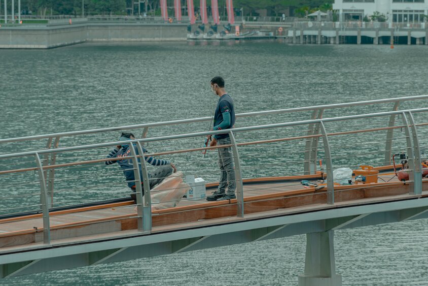 Two men fishing on a bridge