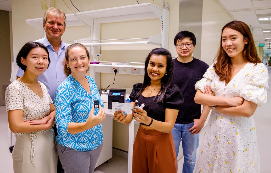 SMART and NTU scientists with the rapid test kit that detects levels of COVID19 antibodies