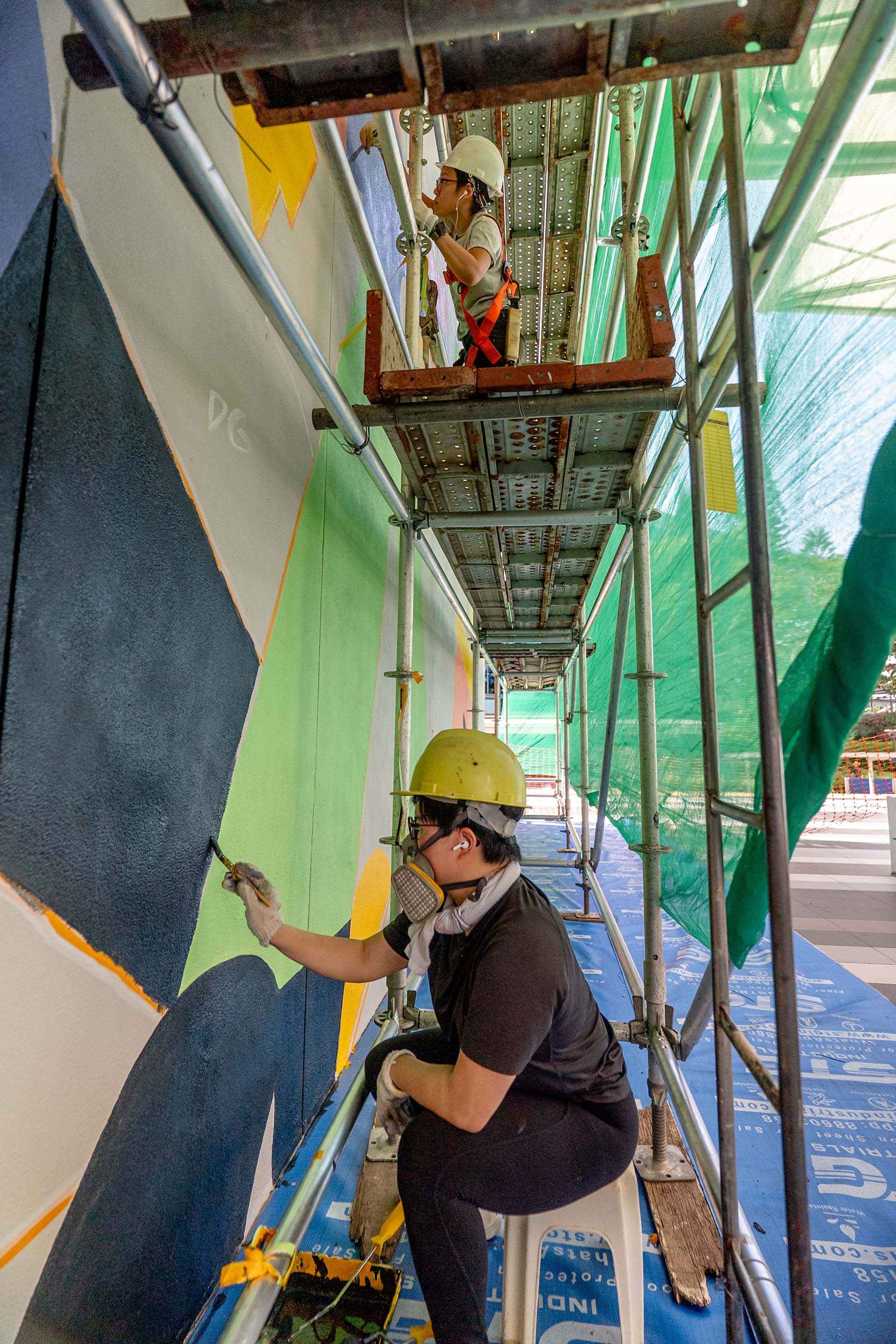 8EyedSpud painting the 6.4m tall Becoming mural on scaffolding