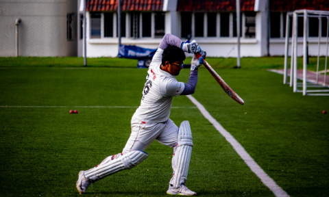 NTU Cricket team player batting a ball