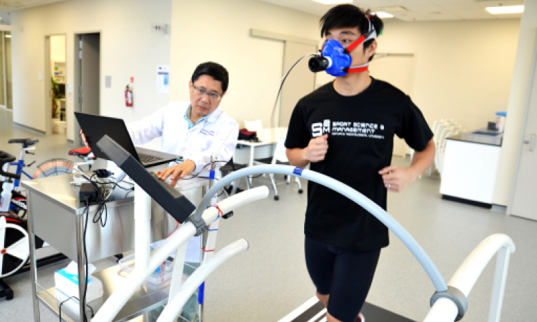 Students running on a treadmill with scientific equipment