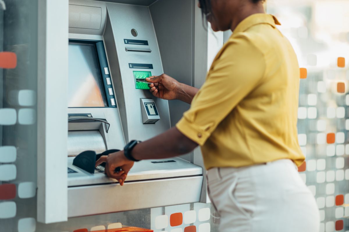 woman using an atm machine and a credit card