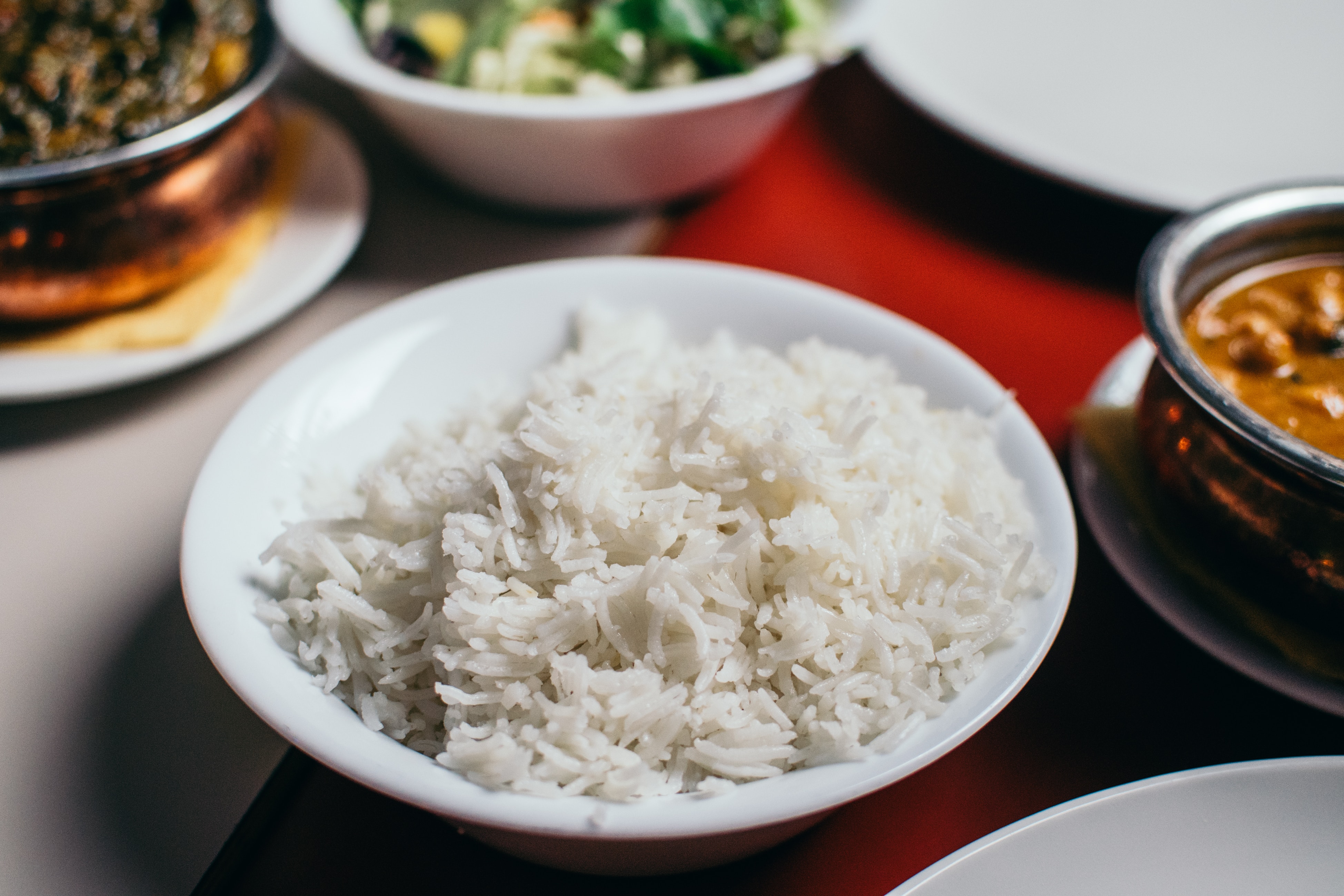 A bowl of rice surrounded by dishes