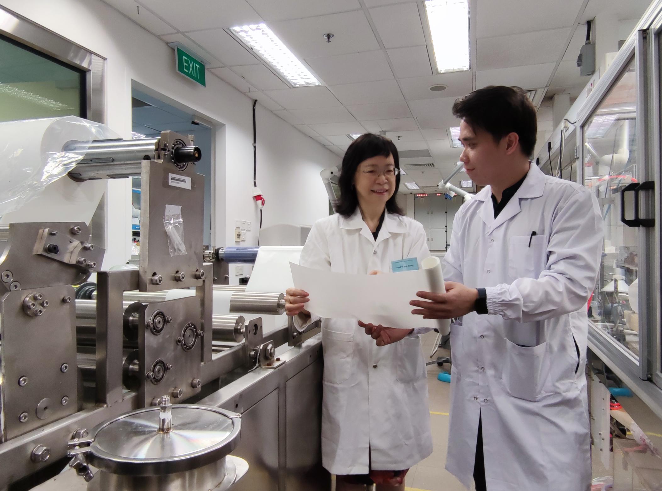 NTU Prof Wang Rong, the director of the Singapore Membrane Technology Centre at NEWRI (left), and the centre’s research fellow Dr Lai Gwo Sung with a roll of an aquaporin-based membrane and the machine that makes the membrane