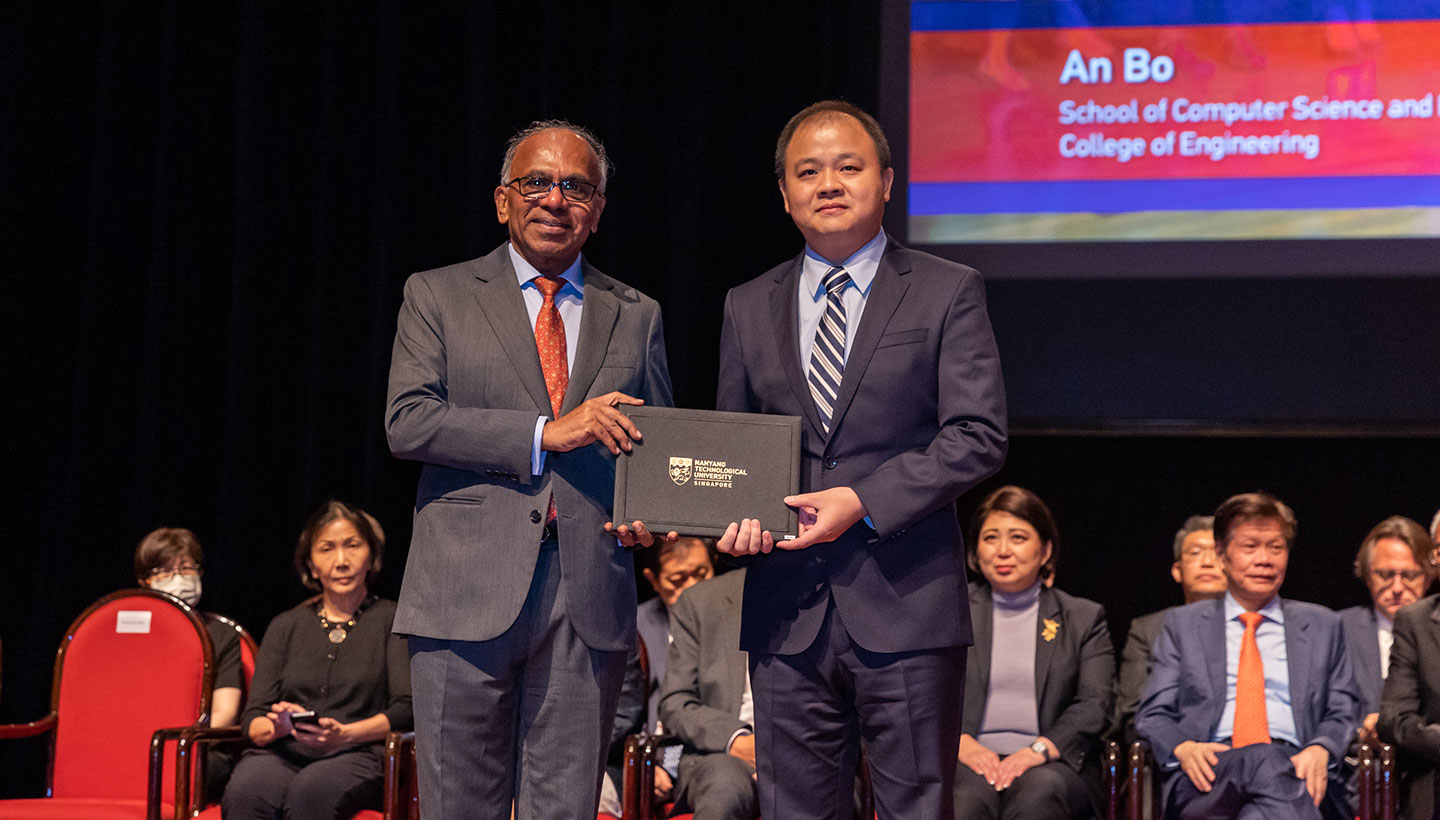 Photo of Professor receiving certificate from NTU President on stage.
