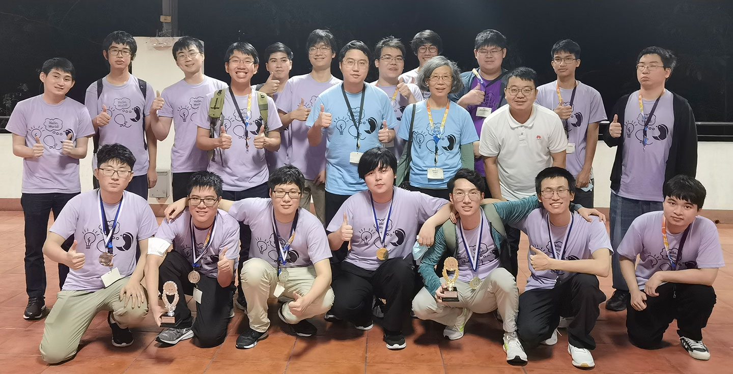 Group photo of university students with medals and trophies.
