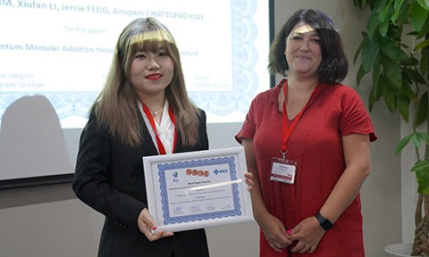 Thumbnail photo of a female PhD student holding an awarded certificate with a lady standing beside her.
