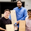 Group of researchers holding “fireproof” wood