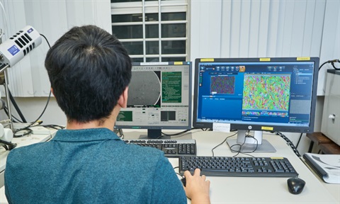 Researcher studying microstructure of 3D printed stainless steel