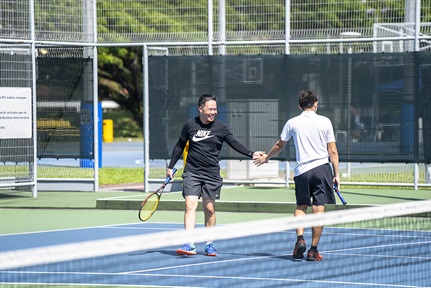 A show of good sportsmanship after a tennis session at NTU Alumni Sports Fiesta