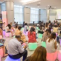 Participants sitting on colour cubes and taking notes in a learning space