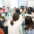 Students sitting in a circle on coloured cubes having a discussion sharing session
