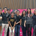 University students standing in front of a pink background.