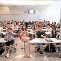 Students showing a thumbs up sign during a campus event with speaker Cheryl Wee