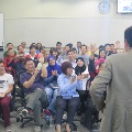 Students clapping, raising hands in unison and smiling during lesson