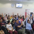 Students raising their hands in unison during a forum