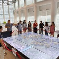 Students surrounding a holographic diagram of buildings and houses at the Launchpad learning journey