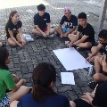 Students sitting in a circle for team building activity, sketching ideas on mahjong paper
