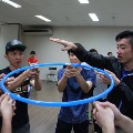 Students having a team bonding activity with a blue hula hoop