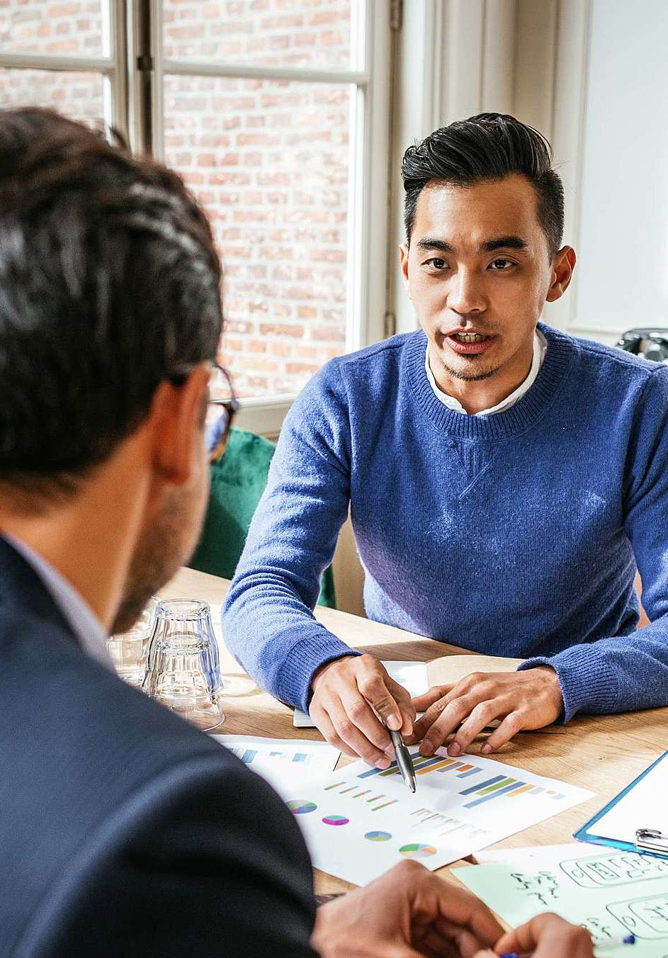 Male student points out data and statistics in a team meeting