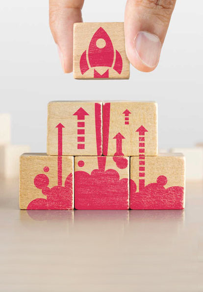 Wooden building blocks with red rocket blasting off into space