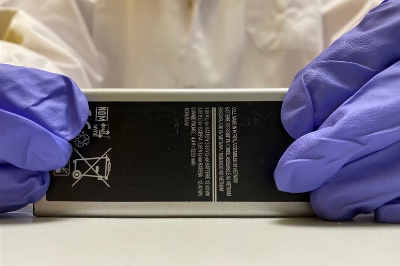 Scientist showing a battery used for their research