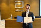 Tze Kean receiving a Certificate of Appreciation from Abbott for his case study project.
