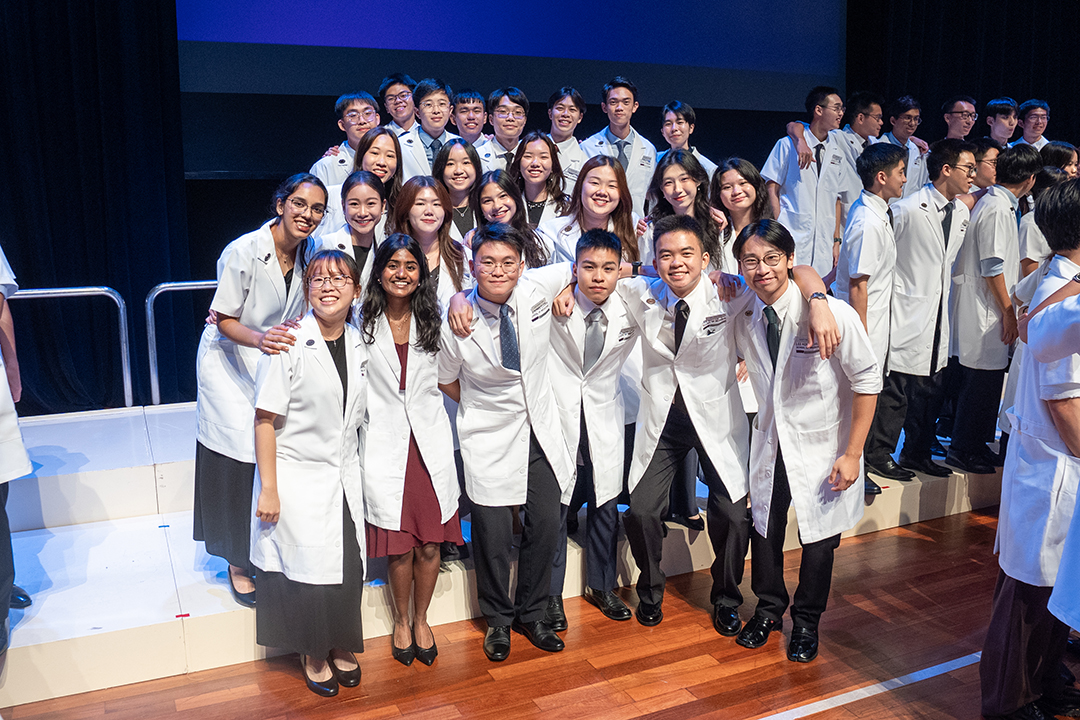Students smiling at white coat