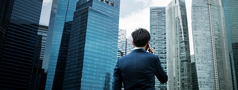 Man on a phone, walking in a financial business district
