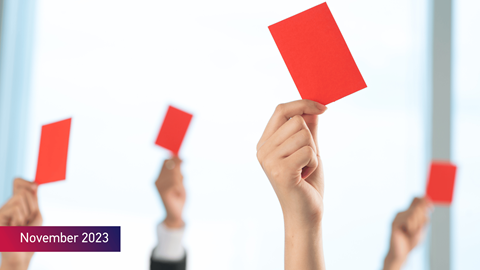 A group of people declined something showing red card on the foreground with the text November 2023