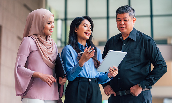 iPad Lecture Theatre 1 Lady in Blue Top and Malay Girl Wearing Pink Tudung with Senior Male Teacher Closeup (720x432px)