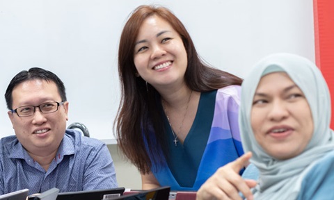 Smiling Group of teachers in blue In Classroom Looking In Distance 2 blue malay tudung (720x432px)