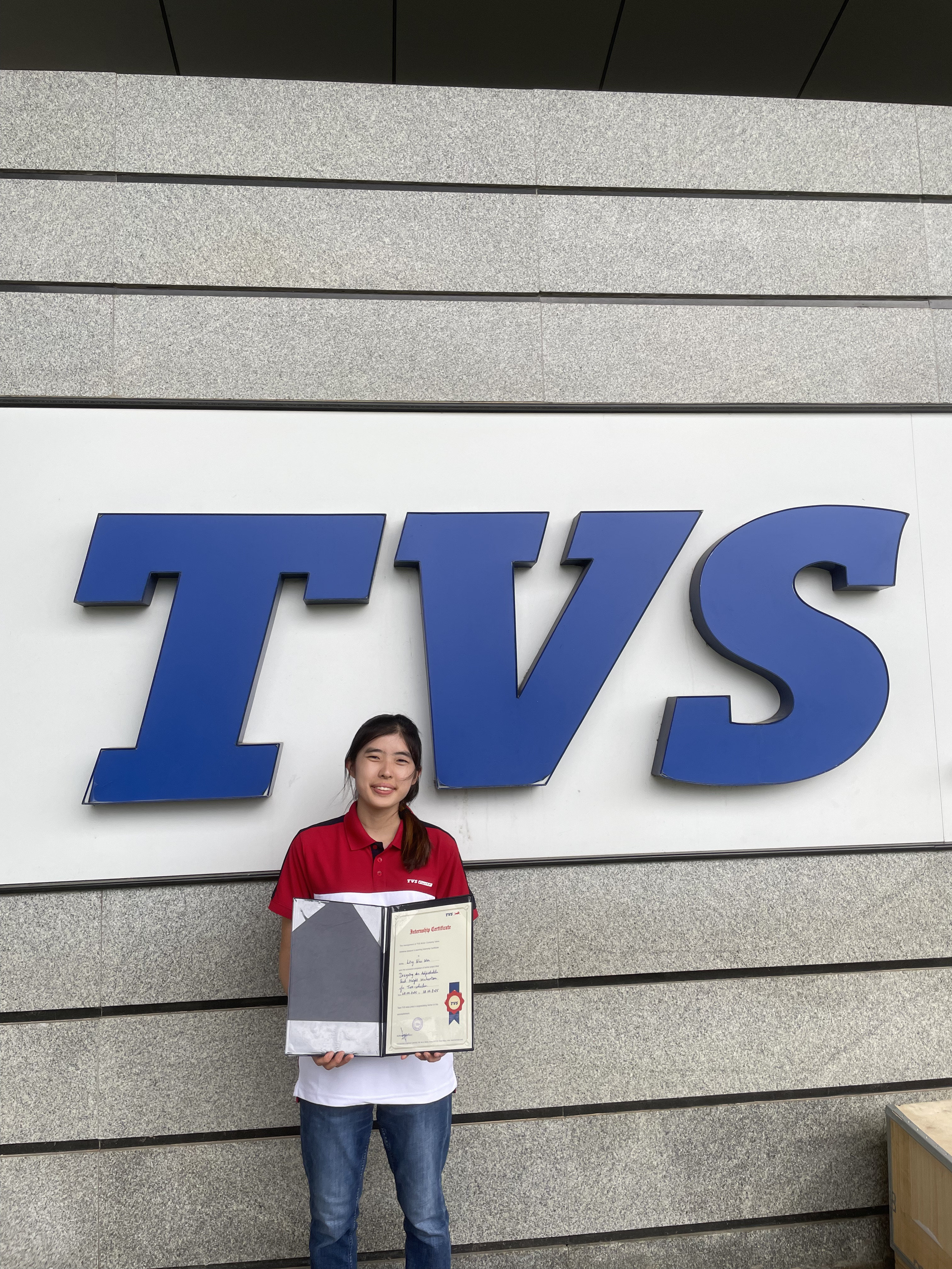 Student in front of TVS logo