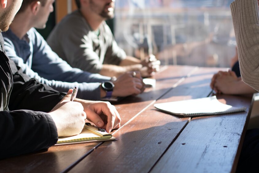 Stock image of a group of people meeting around a table 