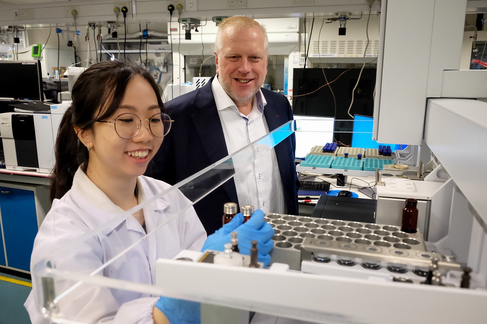 Prof Shane Snyder looking on as a student performs an experiment