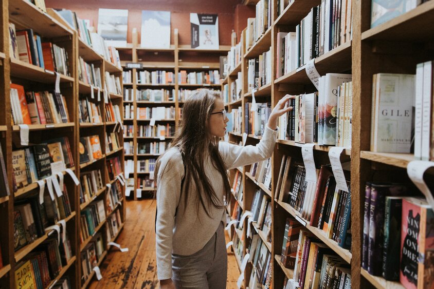 Student in a library looking at books 