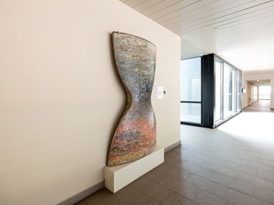 Angled view of hourglass shaped sculpture in a hallway