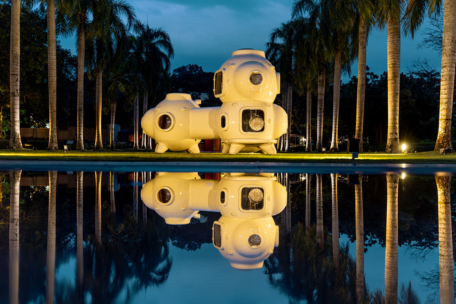 Installation view of Cosmos of Nostalgia by Torlarp Larpjaroensook, night shot with water reflection