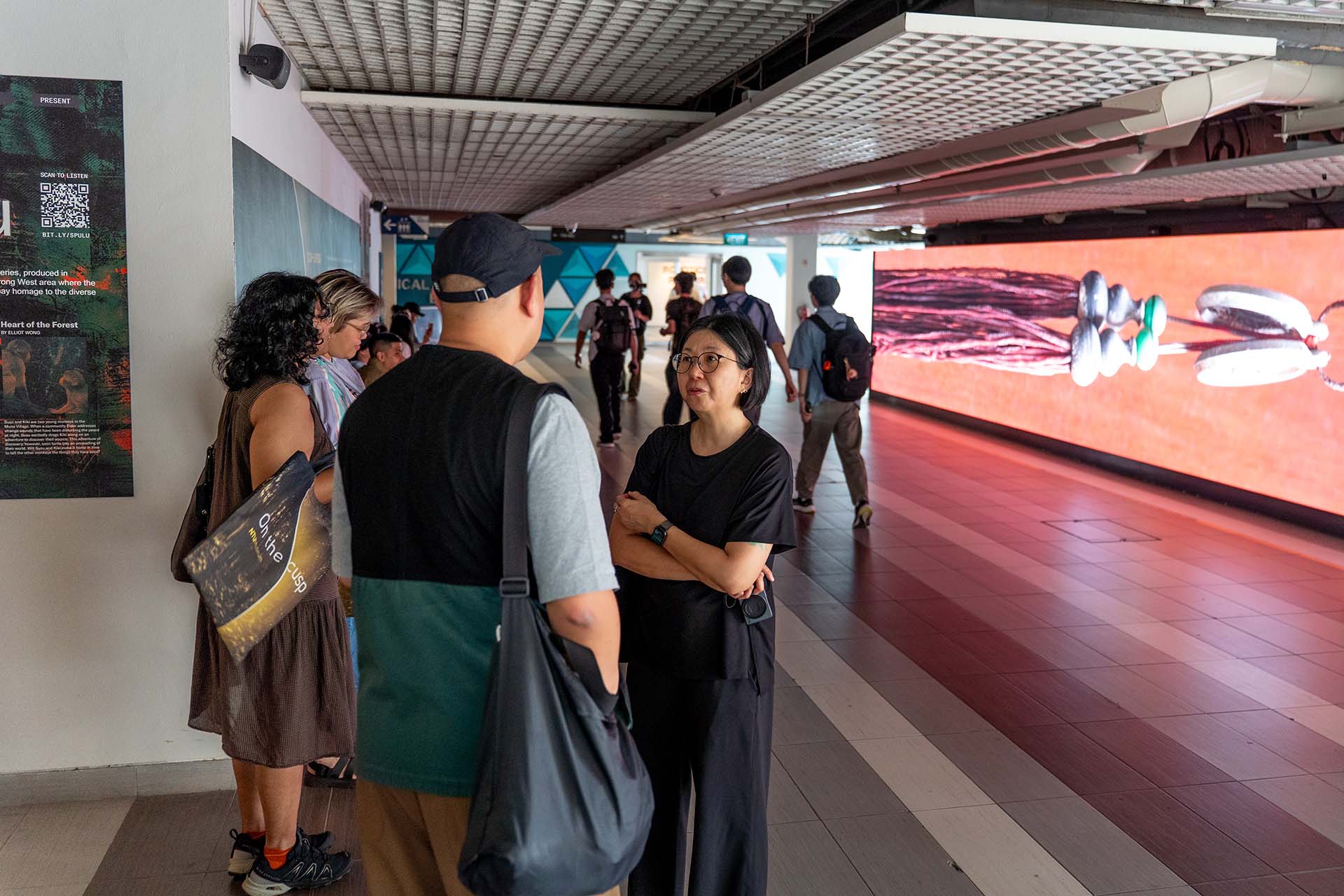 Group of people in front of a long video screen