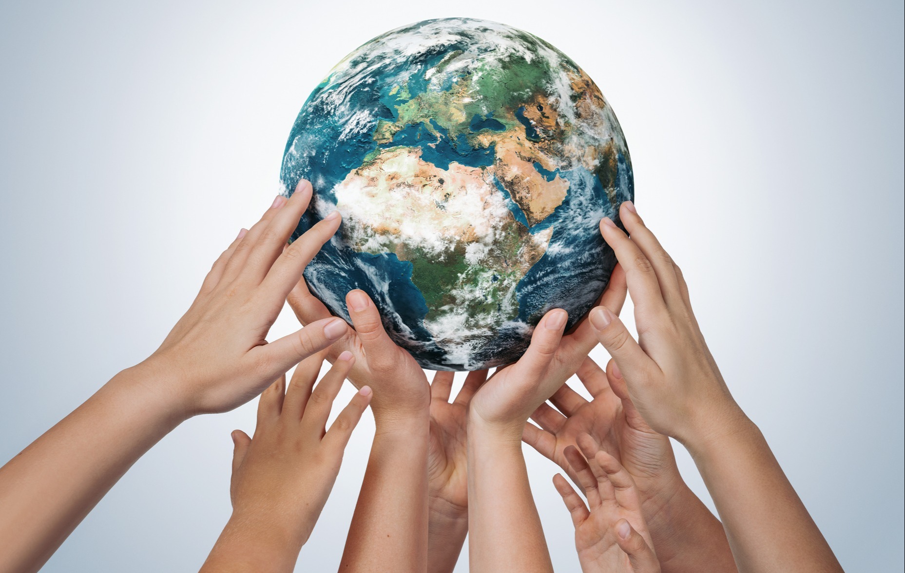 Many children hands holding planet earth
