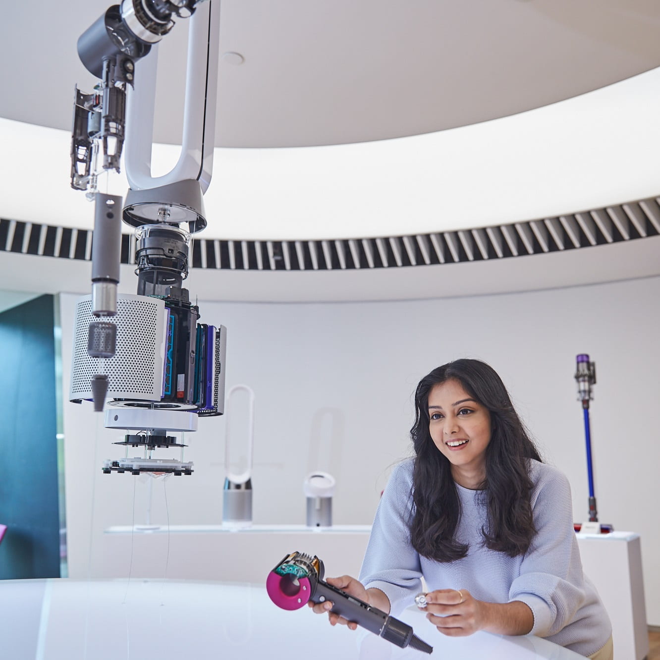 A lady showing how the internal components of a Dyson hair dryer
