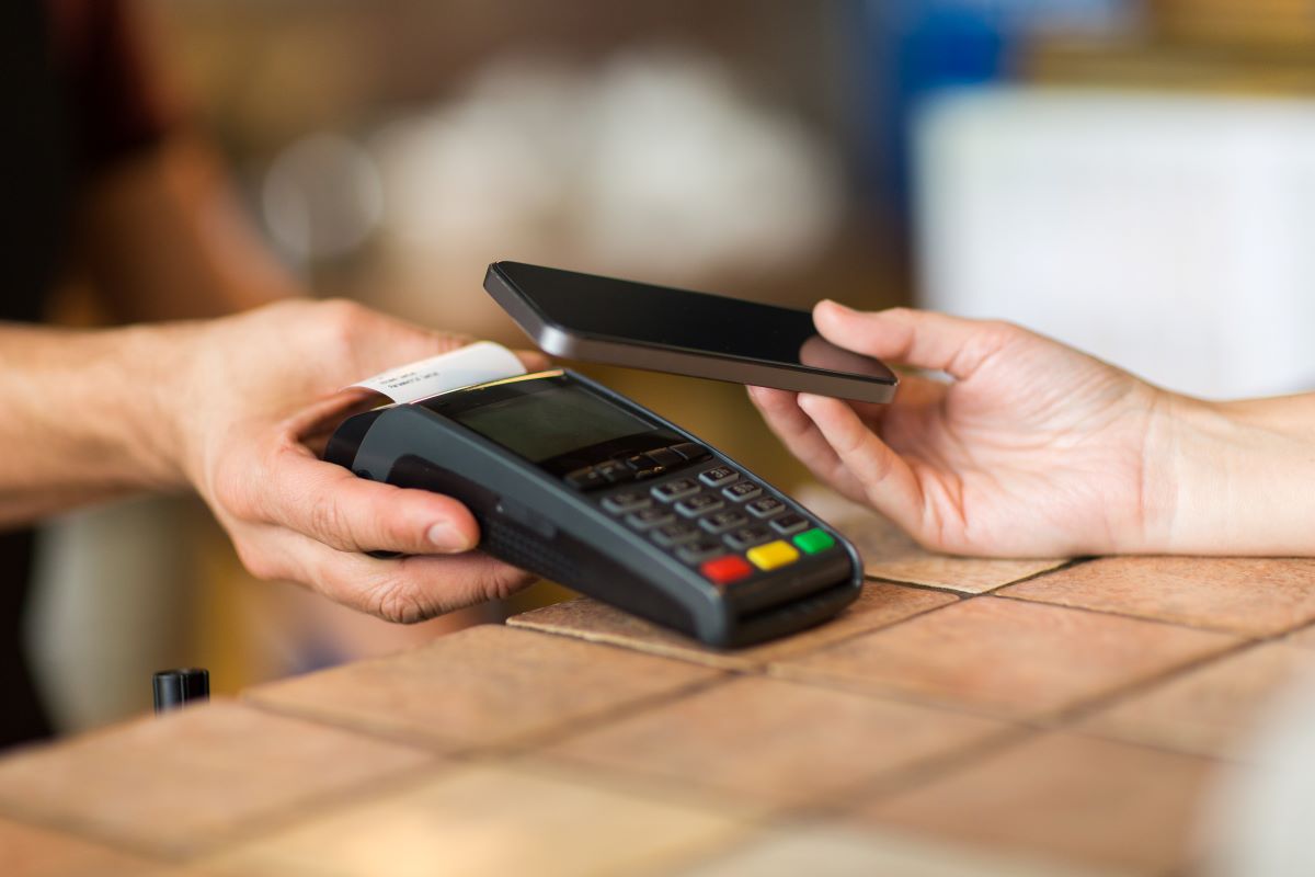 man with payment terminal and customer with smartphone