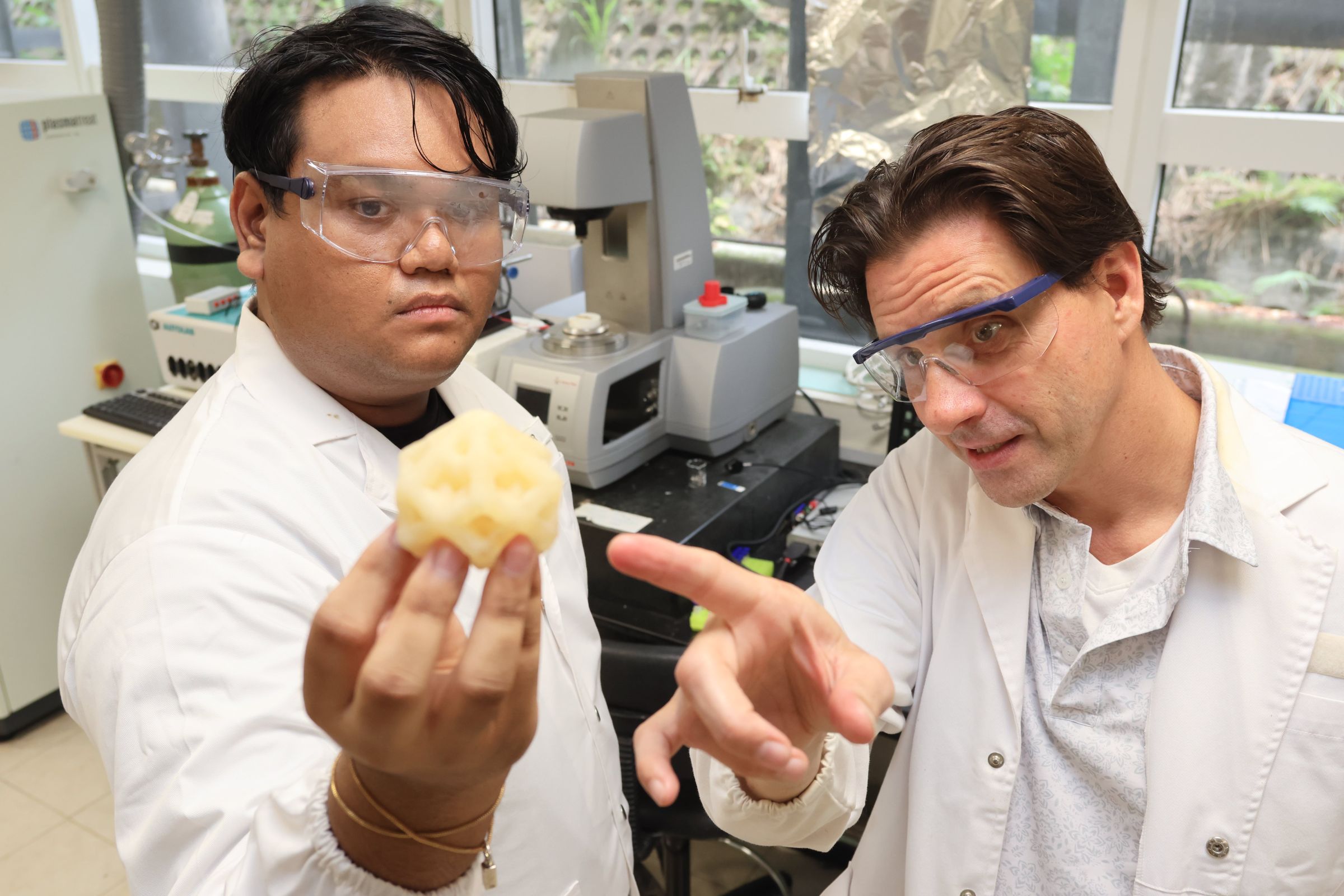 PhD student Naziruddin Ali (L) and Prof Terry Steele discussing a 3D printed model made using the aryl diazirine photoinitiators they developed. Credit: NTU Singapore