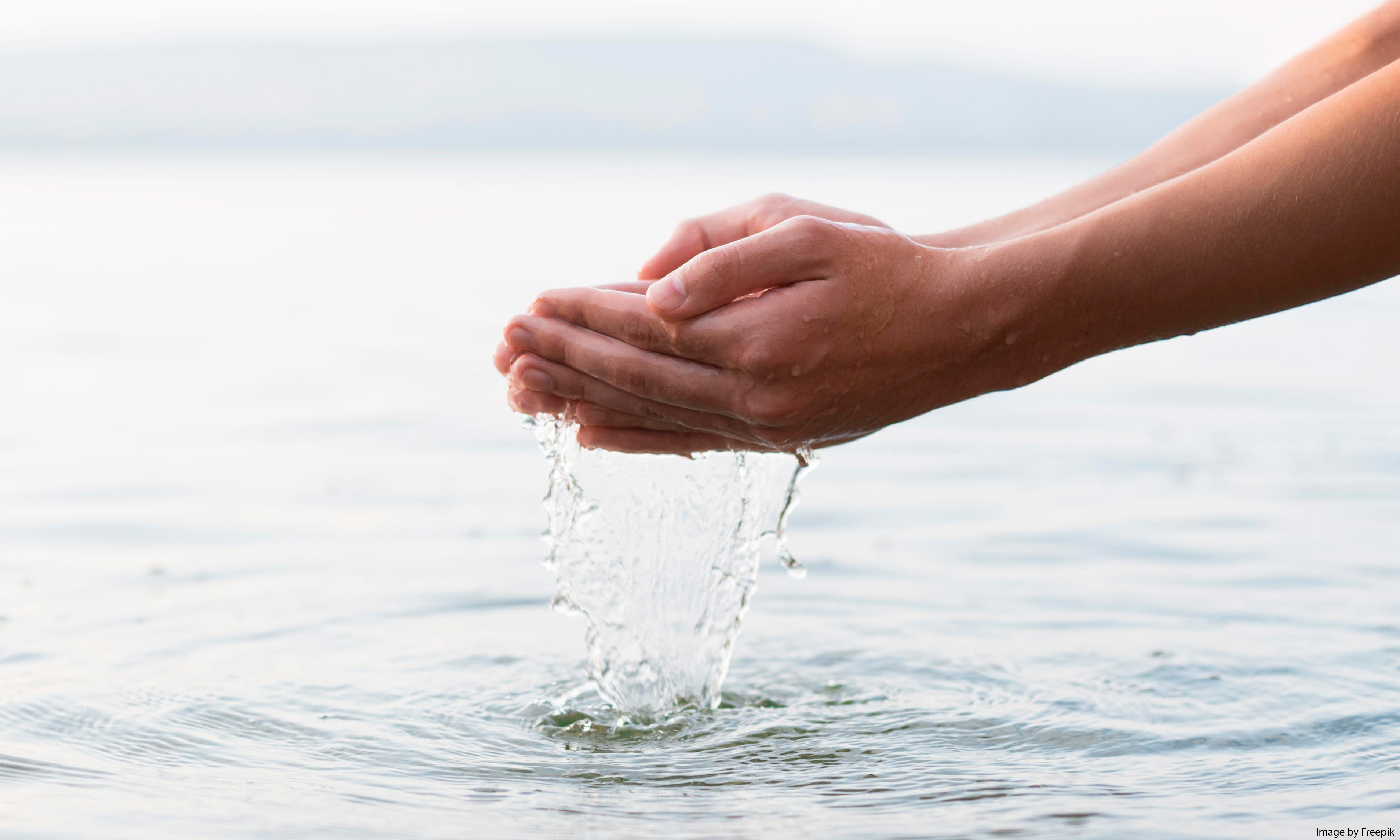 A pair of hands cupping water
