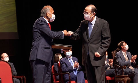 Photo of Prof Zheng doing a fist bump with NTU President on stage.