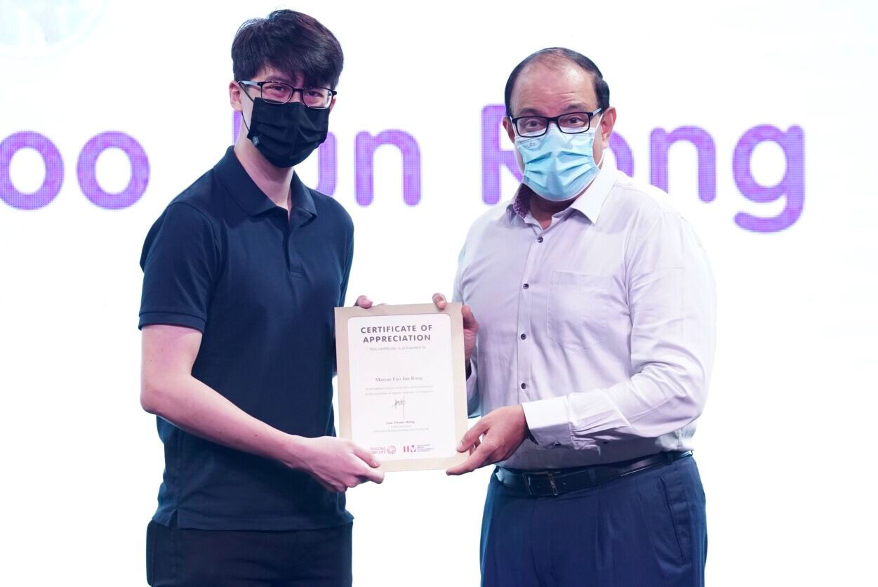 Photo of Marcus Foo Jun Rong (BCG, Year 3) receiving certificate of appreciation from minister..